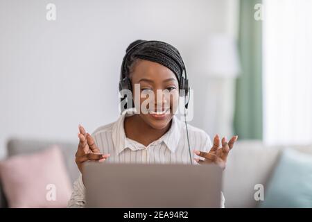 Young black woman with headset having video conference from home Stock Photo