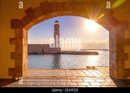The Egyptian lighthouse at the old harbor of Rethimno through a frame of an arched door, Crete, Greece. Stock Photo
