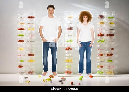 Collage, man and woman, in jeans, in front of tablet tubes, with tablets, studio Stock Photo