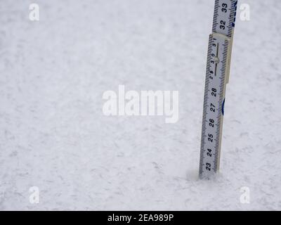 Measure the snow depth with a folding rule Stock Photo