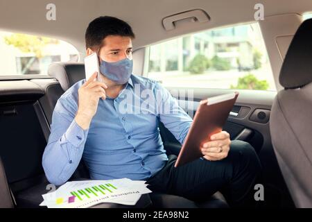 Mature business man with face mask working during travelling to office Stock Photo