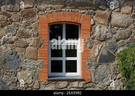 White-framed window on an old stone wall, framed in red brick. From the window of the world series. Stock Photo