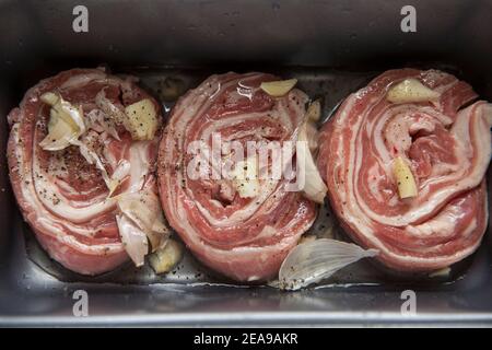 Raw, rolled British lamb that has been marinaded in olive oil, rosemary and garlic in preparation for grilling at home. England UK GB Stock Photo