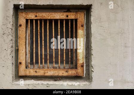 Iron-barred window in suburb of Eastern Europe garage fear of theft first floor of old apartment building rust and aged wall texture with copy space Stock Photo