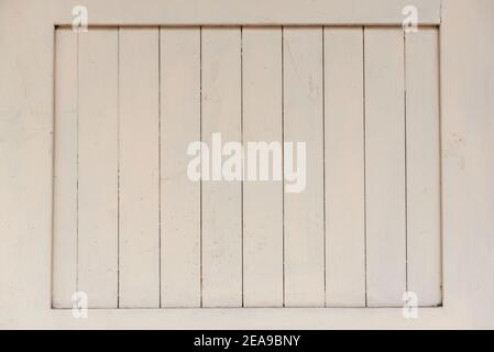 Weathered light gray paint texture on wooden planks of barred over window of renewed house on town street Stock Photo