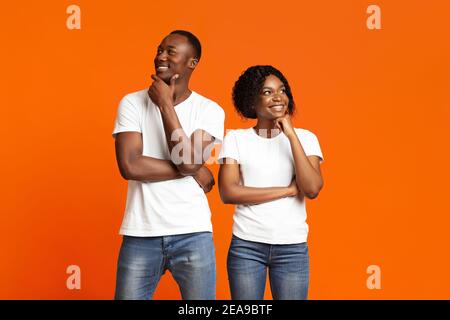 Pensive black man and woman standing by each other, thinking Stock Photo