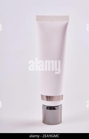 Blank tube of cream, concealer, toiletry. Face base tube with professional cosmetic products isolated on white background. Skincare and beauty concept Stock Photo