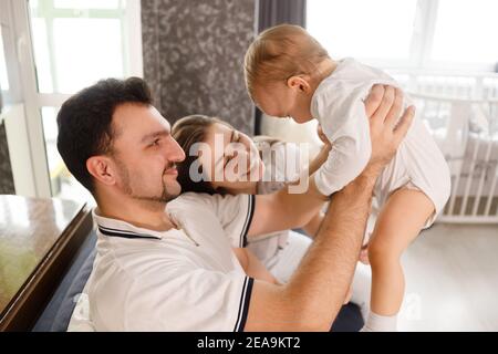 happy family mother father and child son at home on sofa in living room