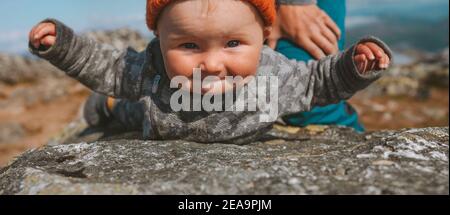 Infant child balancing on rock family travel lifestyle vacation cute baby having fun outdoor Stock Photo
