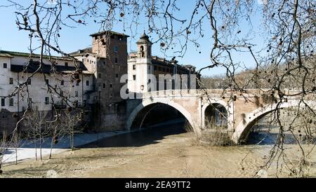 Romantic view of ancient Roman Fabricio bridge well preserved and pedestrian way to go to Tiberina Island on Tiber river in historic Rome downtown Stock Photo