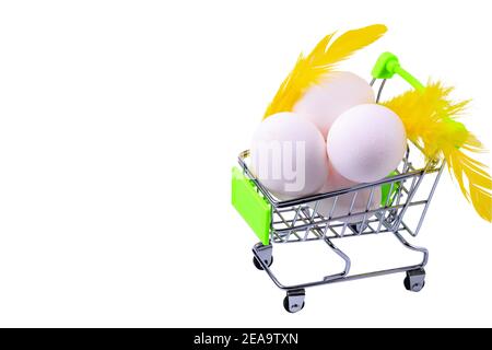 Close up view of Easter eggs in shopping cart on white background isolated. Easter holidays concept background. Stock Photo