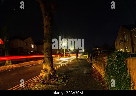 Street lights and car trails on a dark night in Penrith Stock Photo