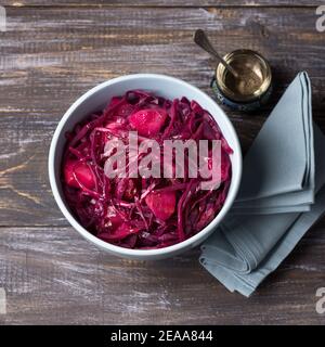 Stewed red cabbage with apples and spices on a wooden background, square. delicious homemade healthy food Stock Photo