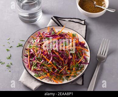 Red cabbage coleslaw salad with cumin and mustard sauce on gray background, top view, horizontal Stock Photo