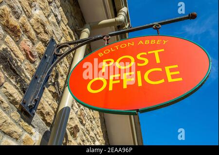 Sign hanging on the wall outside Bolton Abbey Post Office Stock Photo