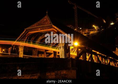 Landscape night shot of the Saint-Jean bridge, in Fribourg, Switzerland, with vehicle light trails in the foreground Stock Photo