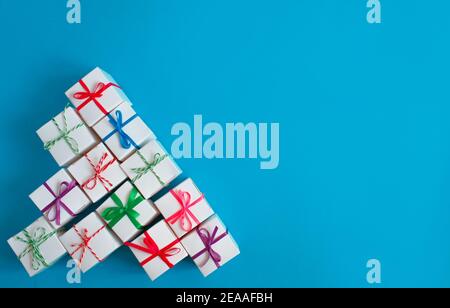 White boxes with colored ribbons lie on a blue background. Top view. Space for the text. Stock Photo