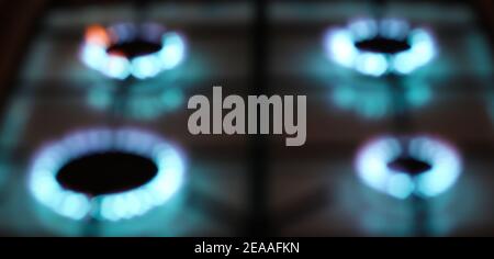 Defocused four blue rings of gas stove burner flames, abstract background Stock Photo