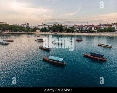 Aerial. Stone town, Zanzibar, Tanzania. Flock of Show Ships near the Zanzibar Coastline in Stone Town on Blue Transparent Water Stock Photo