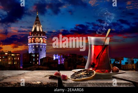 Tea and Galata Tower in Istanbul at night, Turkey Stock Photo