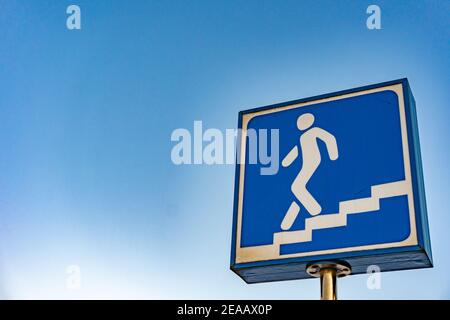 Symbol for subway metro station, blue sign of entrance to the underpass, european traffic underpass walk sign, man walking down the stairs Stock Photo