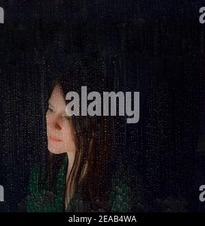 Serious looking thoughtful woman behind a window with raindrops during rain, abstract digital composite image Stock Photo