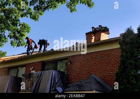 Construction worker on a renovation roof the house installed new shingles Stock Photo