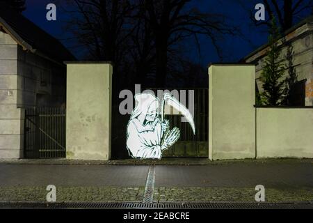 Light painting, Grim Reaper in front of a cemetery entrance Stock Photo