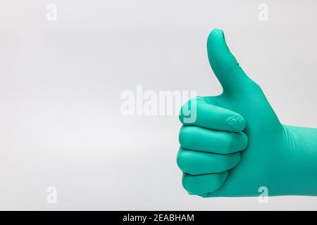 Doctor hand thumbs up, ok sign, detail, green disposable glove, Stock Photo