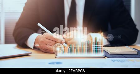 Stock exchange market concept, businessman hand trader press digital tablet with graphs analysis candle line on table in office, diagrams on screen. Stock Photo
