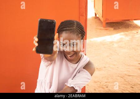 an african lady holding her phone Stock Photo