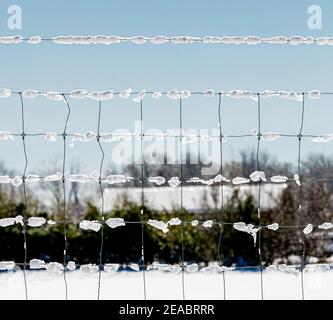 Closeup image of a metal fence with snow and ice Stock Photo