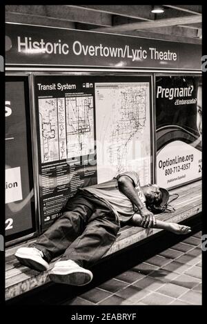 A man sleeps on a bench in the Historic Overtown Metrorail Station in downtown Miami, Florida. Stock Photo