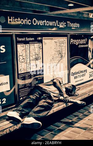 A man sleeps on a bench in the Historic Overtown Metrorail Station in downtown Miami, Florida. Stock Photo