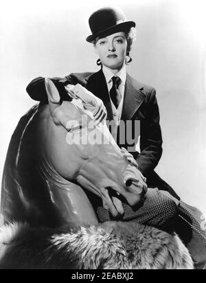1939 , USA : The movie actress  BETTE  DAVIS ( 1908 -  1989 )  in a pubblicity still for the movie   DARK VICTORY  ( Tramonto ) by Edmund Goulding   - CINEMA - FILM - attrice - portrait - ritratto - cavallerizza - amazzone - bombetta - cravatta - tie - collar - colletto - cavallo - horse - scultura - sculpture - pantaloni - pants   - derby hat - cappello - pelliccia - fur -     ----  Archivio GBB Stock Photo