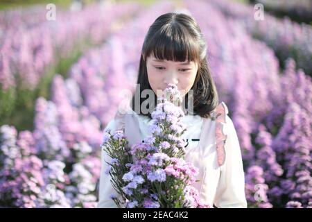 Portrait asian girl with purple flowers background Stock Photo