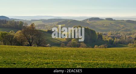 View over the hills of the Hessian Rhön biosphere reserve in spring near Poppenhausen. Stock Photo