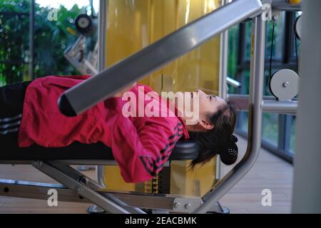 Young woman using a chest press machine - Stock Image - C047/0760 - Science  Photo Library