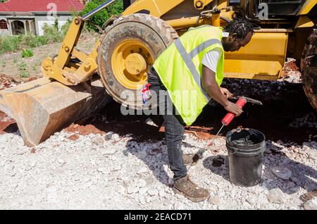 Equipment Operator Filling Grease Pump With Grease. Stock Photo