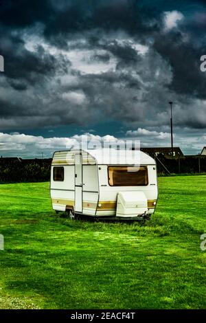 Old caravan in a meadow Stock Photo