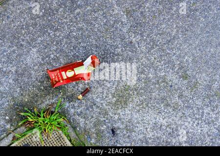 Crumpled pack of Shuang Xi Double Happiness filter cigarettes, hard box, and a filter on a sidewalk in San Francisco, California, USA. Stock Photo