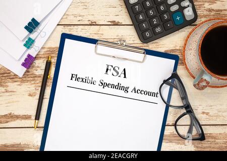 Paper with Flexible Spending Account FSA on the table, calculator and glasses Stock Photo