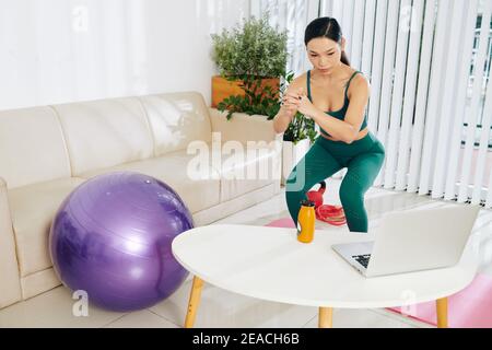 Fit woman doing squats Stock Photo