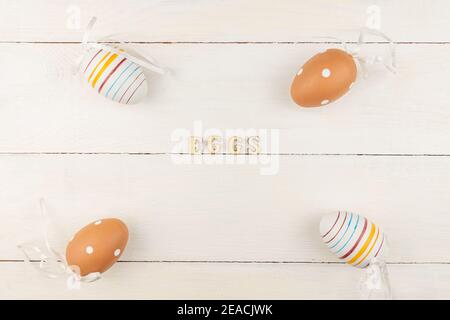 Easter eggs on wooden background. Striped and dotted easter eggs scattered on a table. Stock Photo