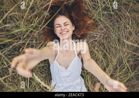 happy woman in haystack stretches hands up and cropped view Stock Photo