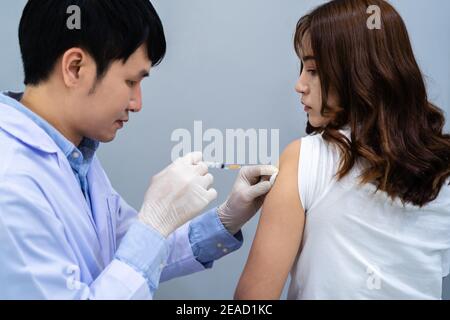 doctor holding syringe and using a cotton before make injection to patient. Covid-19 or coronavirus vaccine Stock Photo