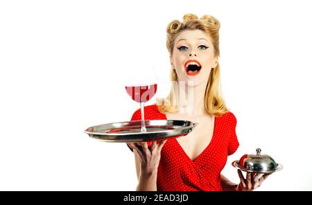 Woman with red wine. Alcohol presentation. Pin up waiter with wine and service tray. Restaurant serving. Studio isolated portrait. Stock Photo