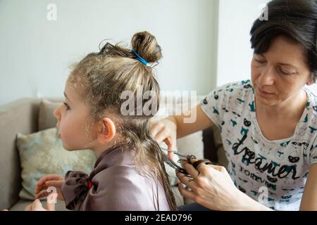 Young woman in home bathroom cutting her own hair with scissors Stock Photo  - Alamy