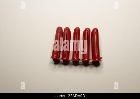cluster of red wall plugs isolated on a plain white background Stock Photo