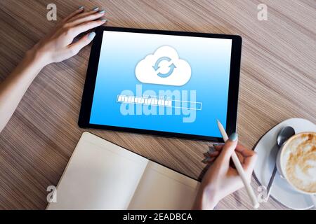 Cloud synchronization progress bar on tablet screen. Data storage and protection. Technology and internet concept Stock Photo